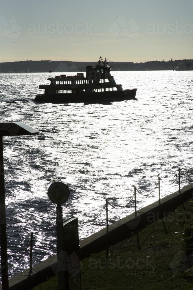 Silhouette of a ferry on waters of sydney harbour - Australian Stock Image