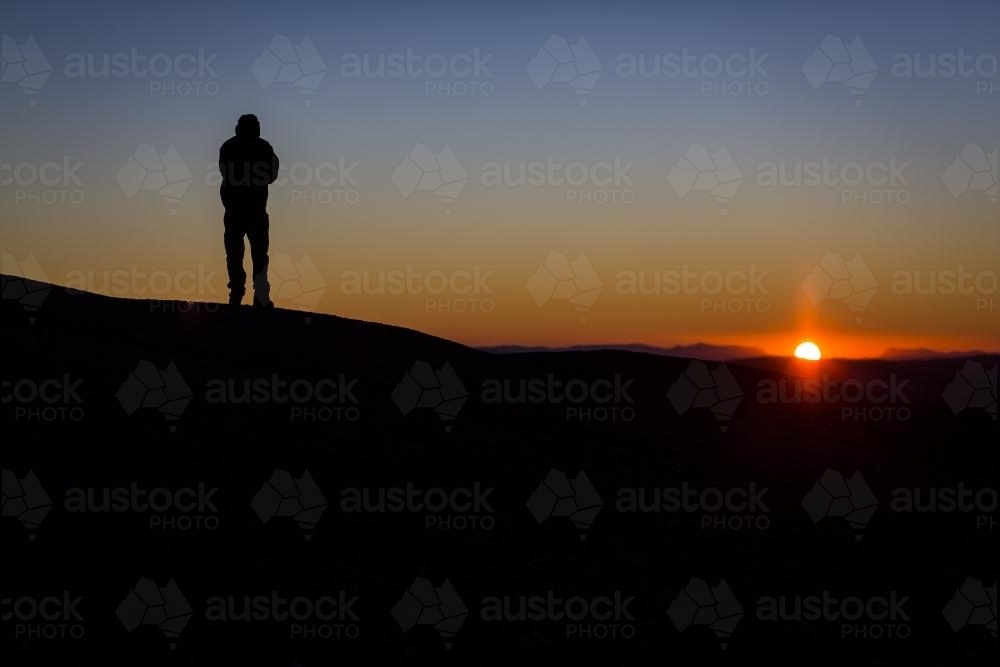 Silhouette of a hiker at sunrise - Australian Stock Image