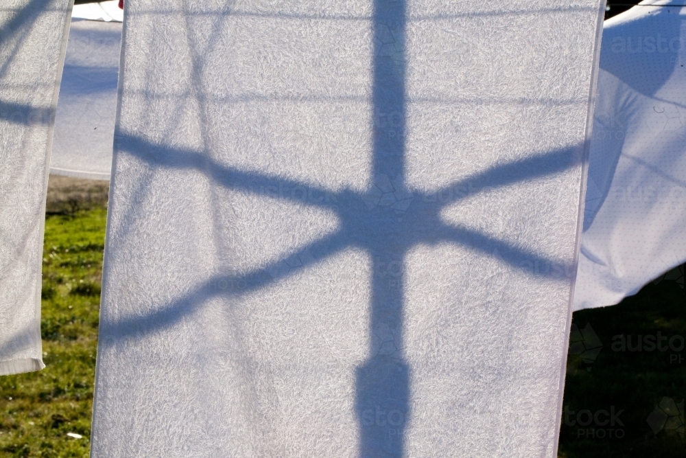silhouette of a hills hoist washing line against washing - Australian Stock Image