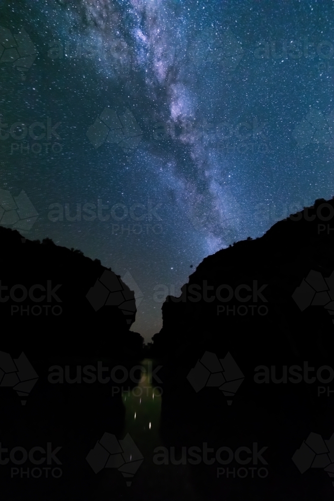 Silhouette of cliffs with night sky with milky way and stars - Australian Stock Image