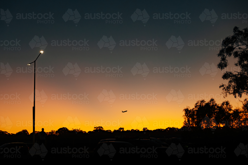Silhouette of commercial airplane flying in the sky at sunset. - Australian Stock Image