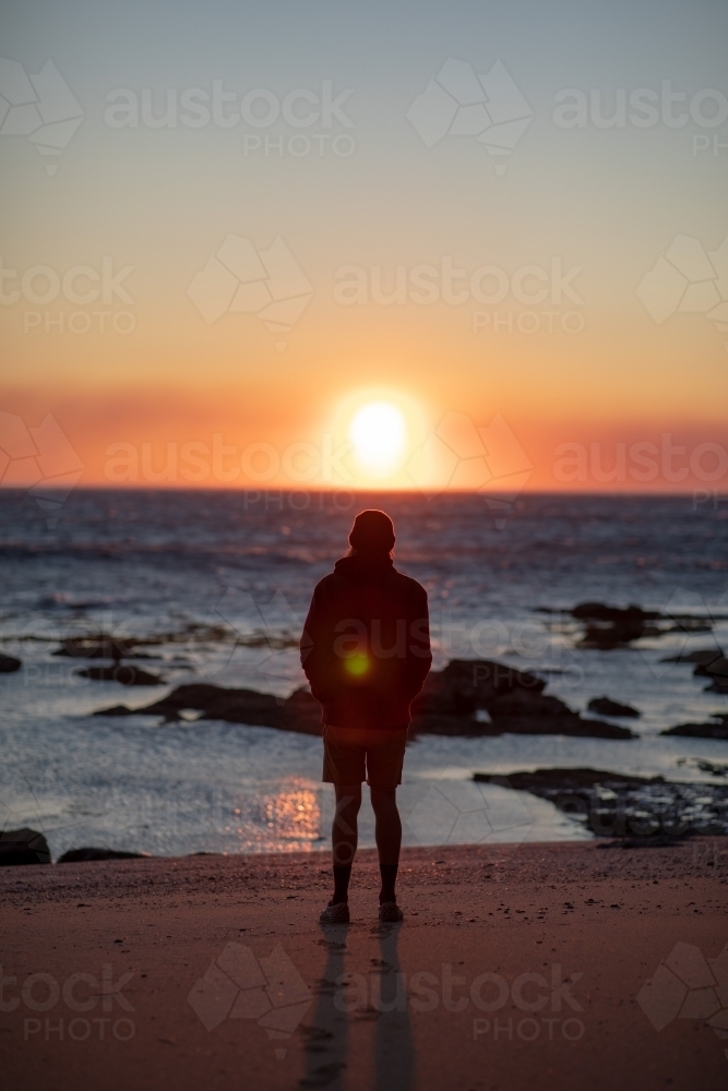Silhouette of Man on Beach Looking at Sunrise - Australian Stock Image