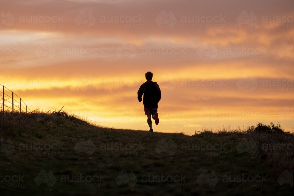 Silhouette of Man Running at Sunrise - Australian Stock Image