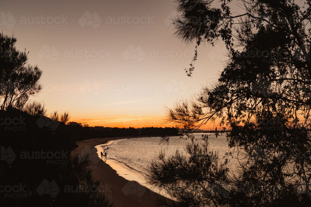 Silhouette of people enjoying Whiting Beach at Yamba at sunset - Australian Stock Image