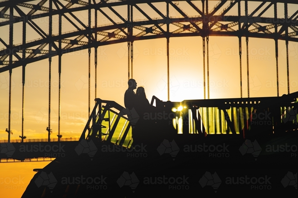 silhouette of people on a boat under Sydney Harbour Bridge - Australian Stock Image