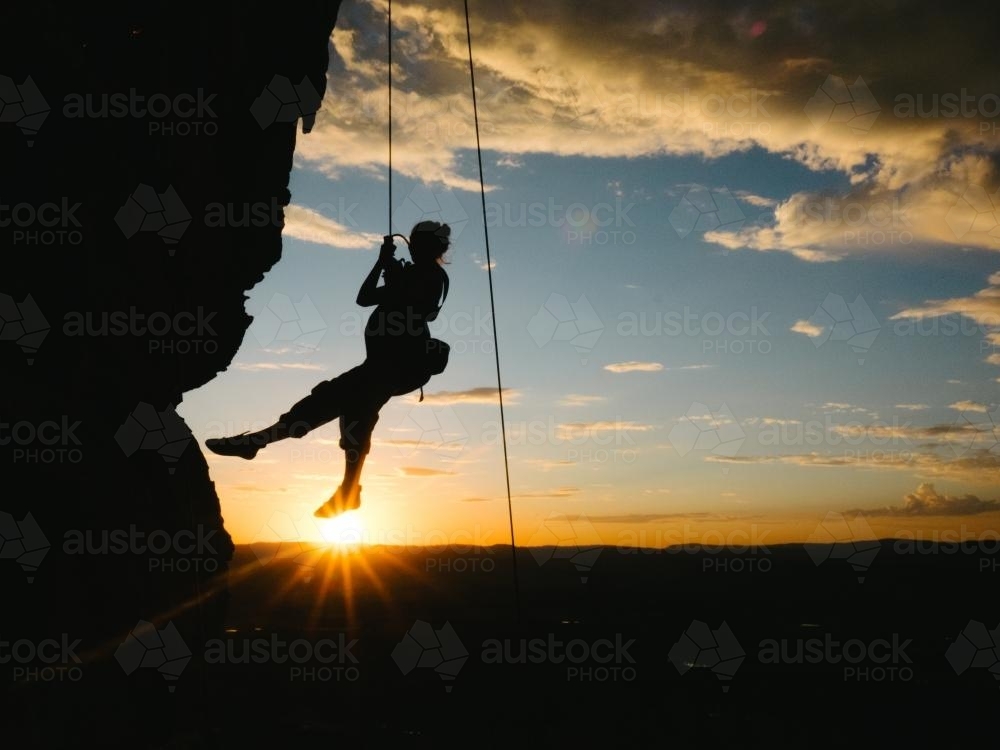 Image Of Silhouette Of Pregnant Woman Abseiling At Sunset