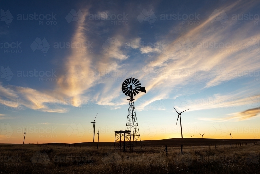 silhouette of windmill and turbines at dusk - Australian Stock Image
