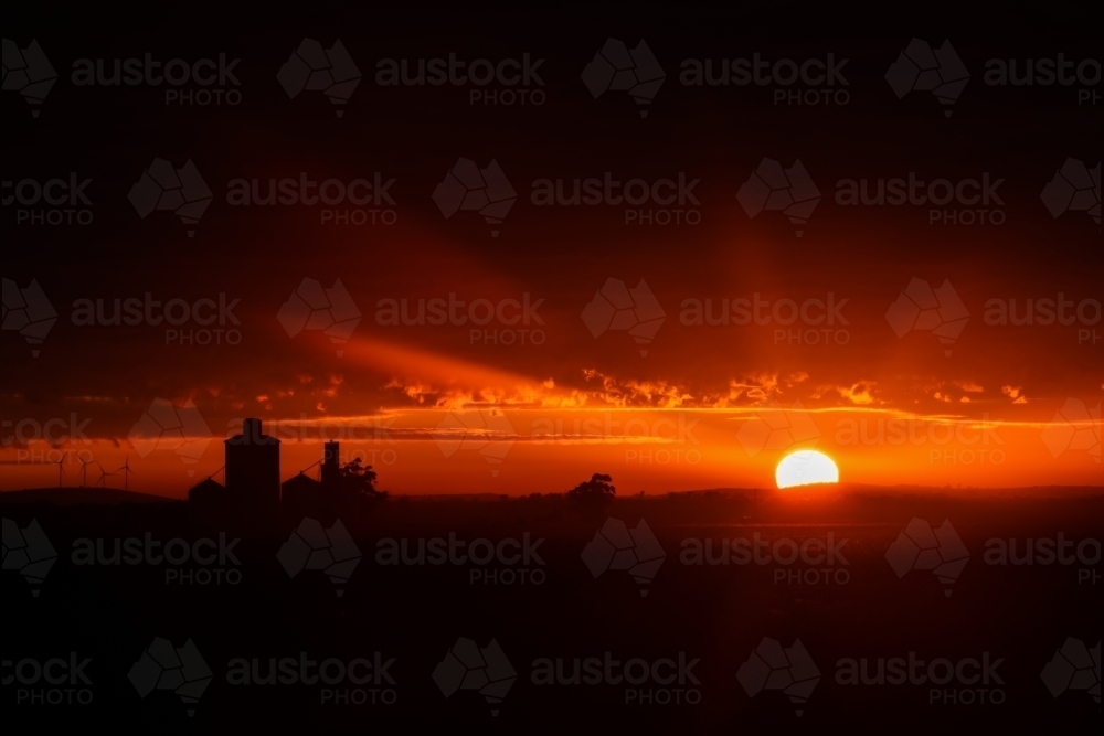 silhouette shot of sunset with orange and black skies - Australian Stock Image