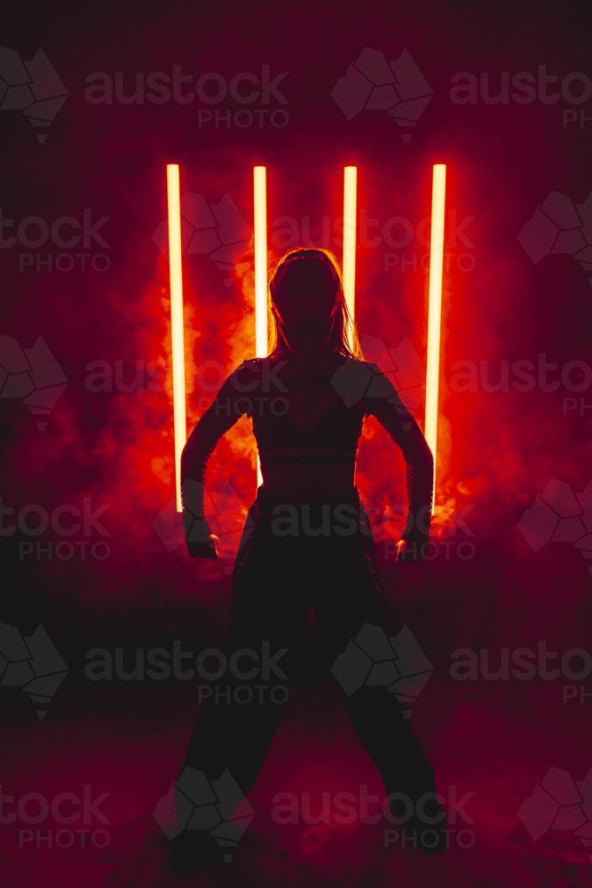 Silhouette Woman with Red Neon Light Bars and Smoke - Australian Stock Image