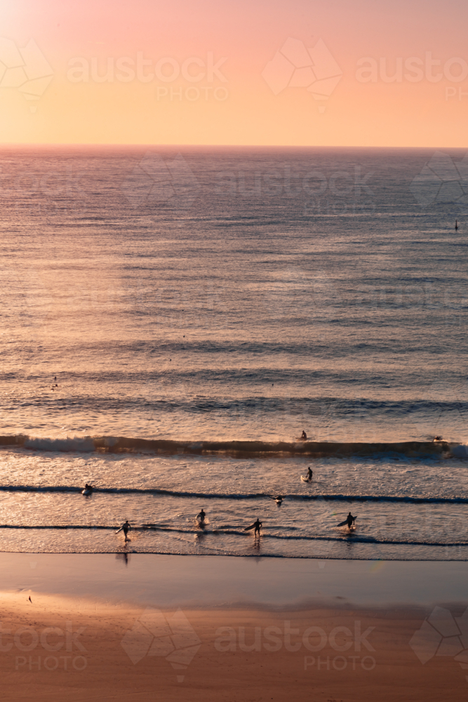 Silhouettes and shadows of early morning surfers at first light at Yamba Main Beach - Australian Stock Image