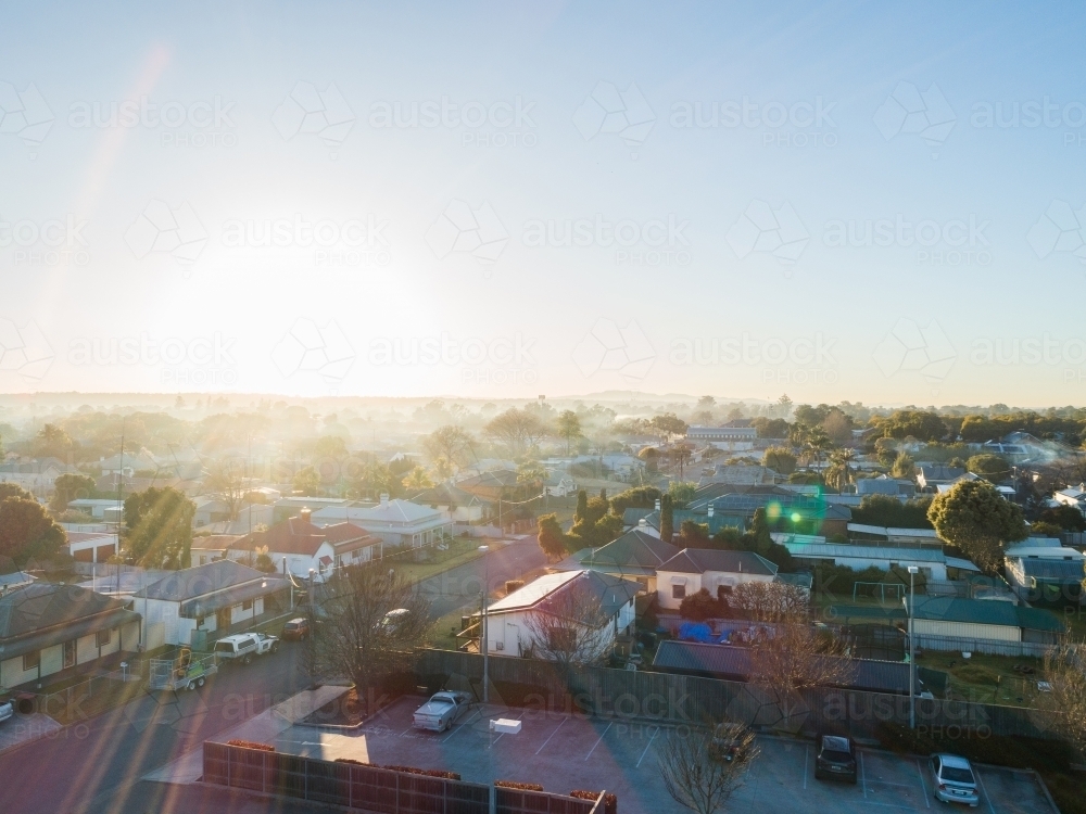 Silver sun rays over town on misty morning in Australia in winter - Australian Stock Image