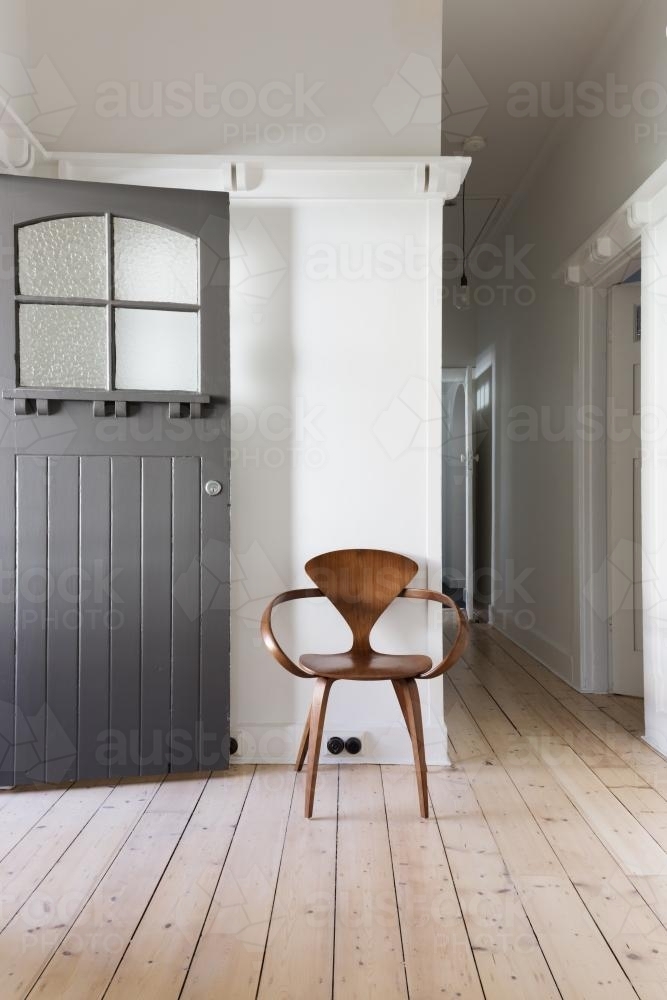 Simple decor of classic wooden chair in renovated apartment entry - Australian Stock Image