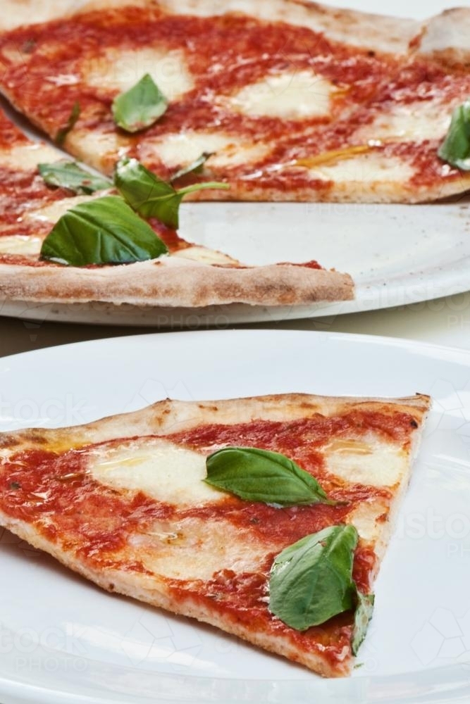 simple  pizza with basil leaves - Australian Stock Image