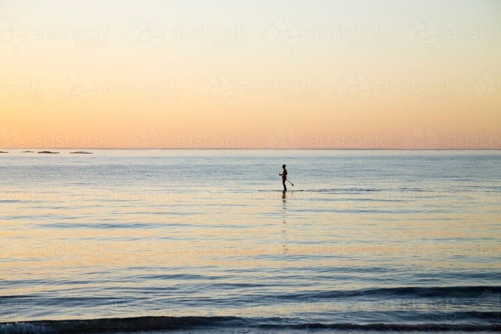single paddle boarder at dawn - Australian Stock Image