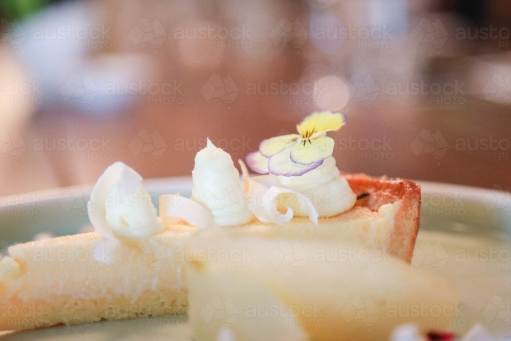 Single piece of cheesecake plated up in restaurant setting - Australian Stock Image