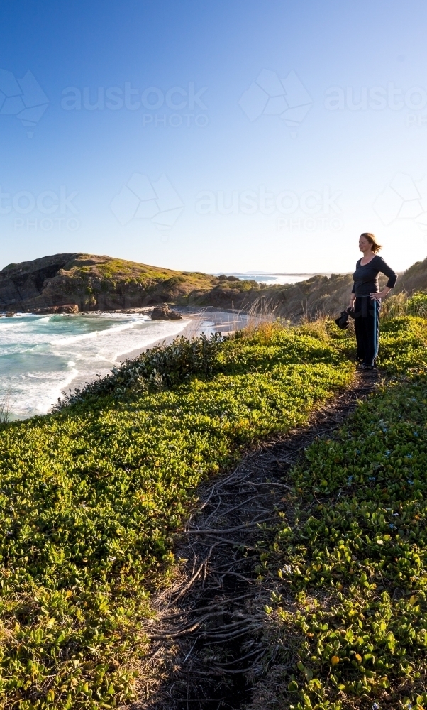 Single woman looking out towards a beach - Australian Stock Image