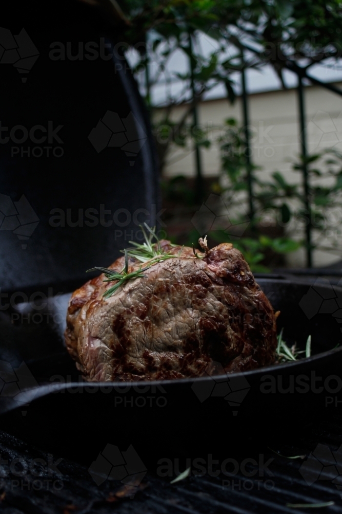 Sirloin steak resting in a skillet on the bbq - Australian Stock Image