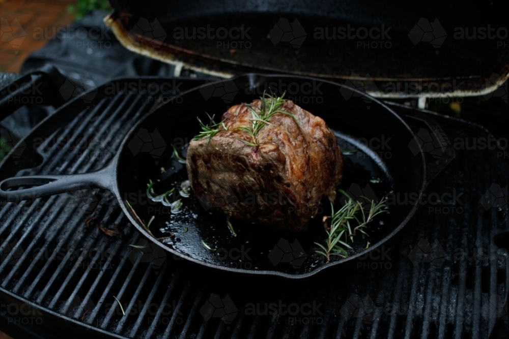 Sirloin steak resting in a skillet on the bbq - Australian Stock Image