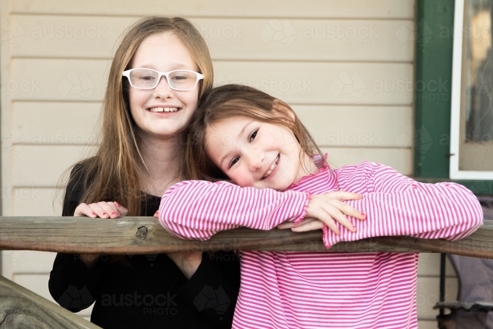 Sisters posing together on the veranda - Australian Stock Image