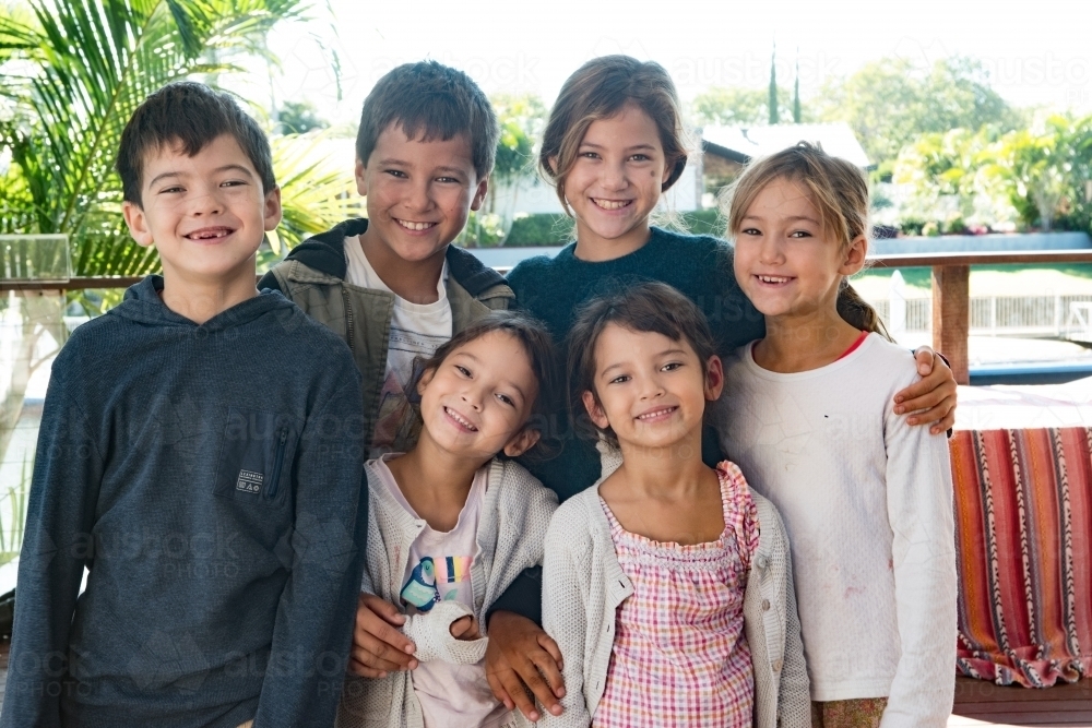 Six diverse culture children standing together smiling at camera. - Australian Stock Image