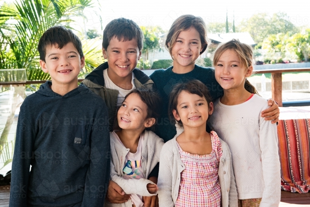 Six diverse culture children standing together smiling at camera. - Australian Stock Image