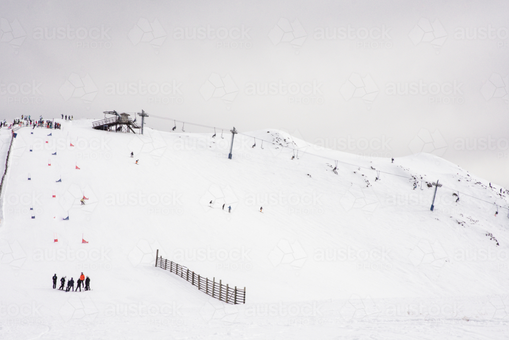 Ski lift and ski run with race course marked out - Australian Stock Image