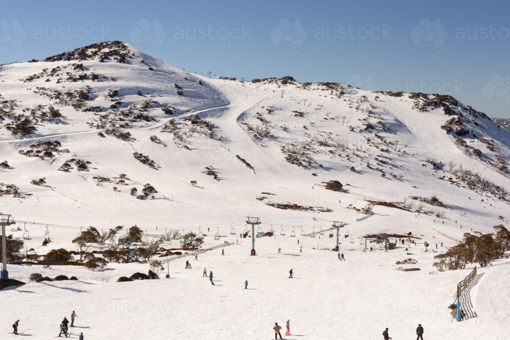 Skiers and snowboarders in a snowy landscape at Perisher, Snowy Mountains Australia - Australian Stock Image