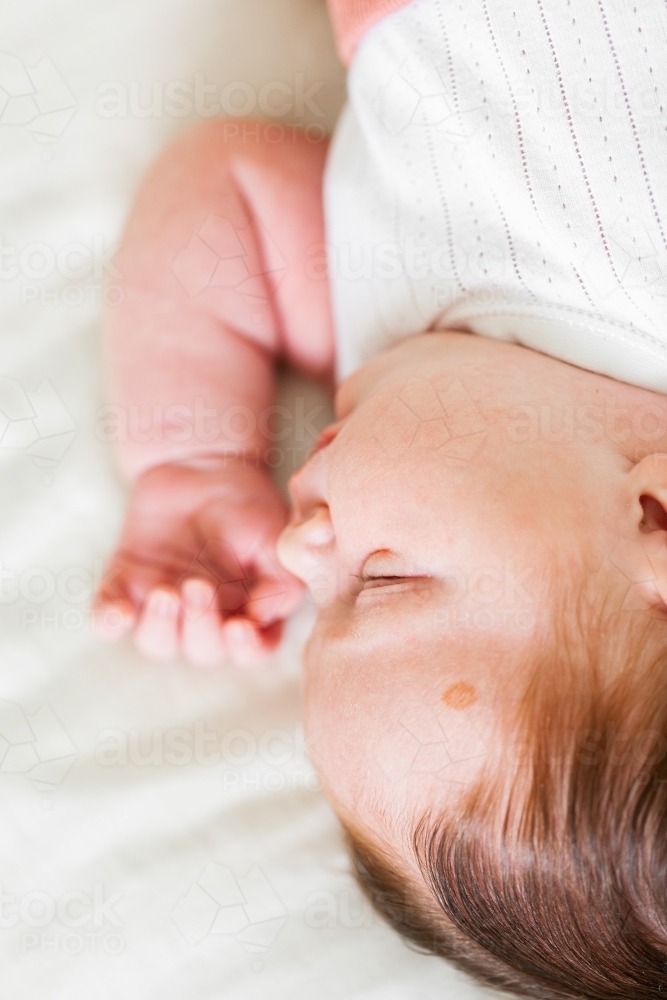 Image of Sleeping newborn baby on white with lots of hair Austockphoto