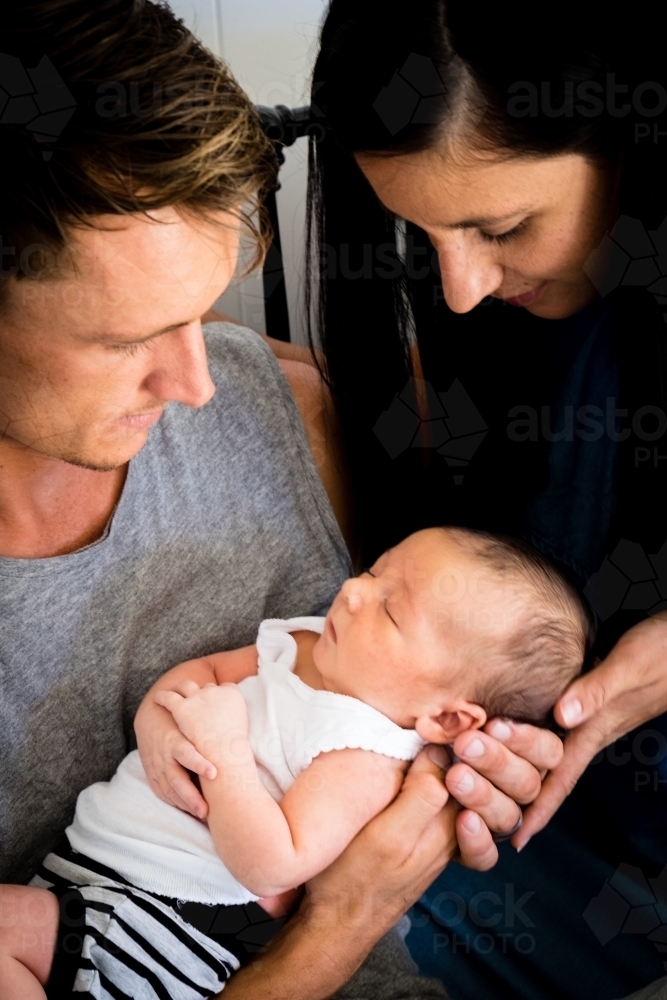 Sleeping Newborn being held by Father with Mother looking on - Australian Stock Image