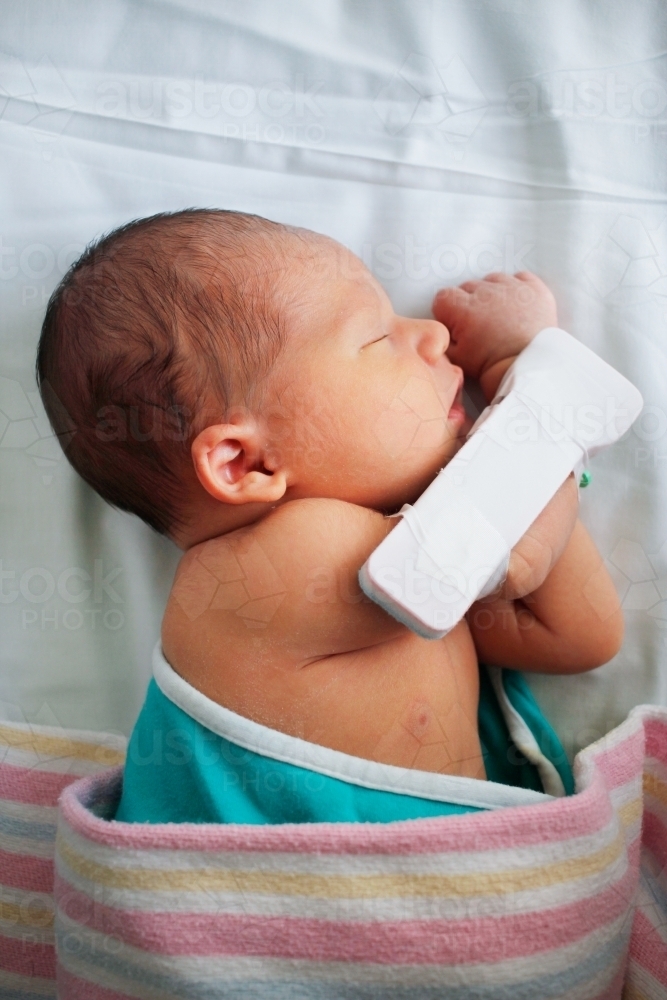 Sleeping newborn in hospital bassinet - Australian Stock Image