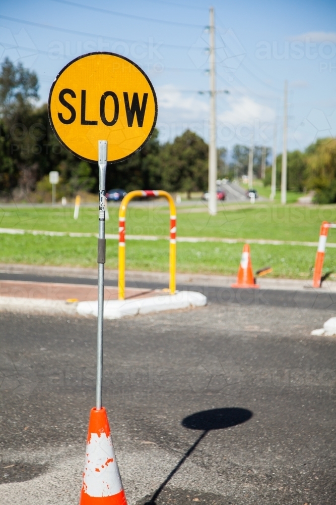 Slow road work lollipop sign in road cone - Australian Stock Image