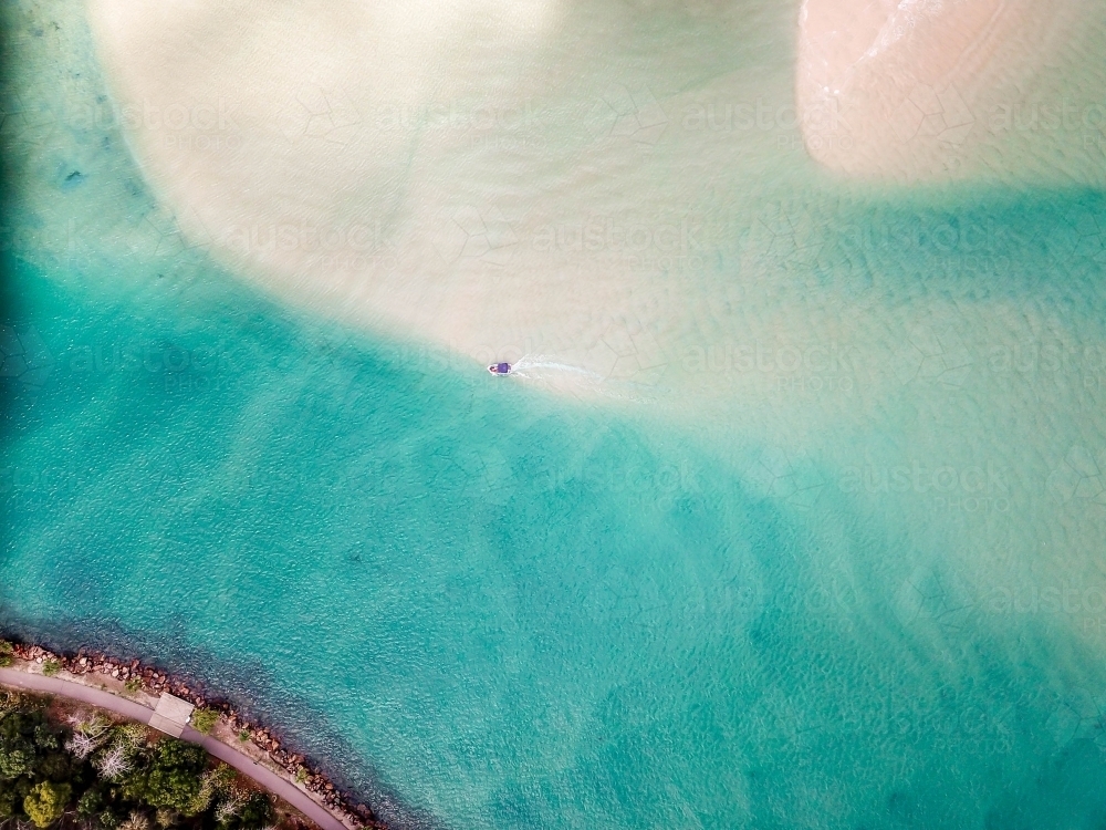 Small boat and sand bar and blue water - Australian Stock Image