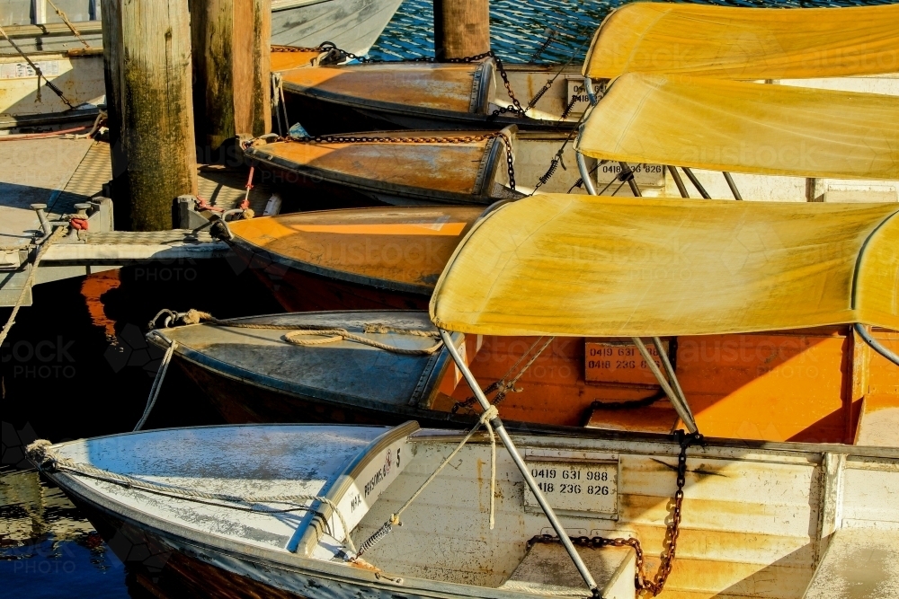 Small boats for hire tied up at jetty - Australian Stock Image