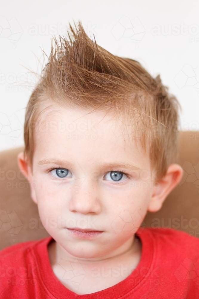 Small boy with serious face, staring at the camera - Australian Stock Image