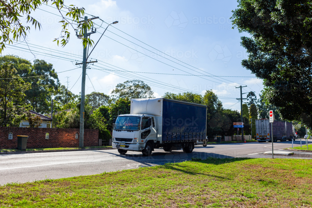 Small delivery truck traveling on highway through country town of Singleton - Australian Stock Image