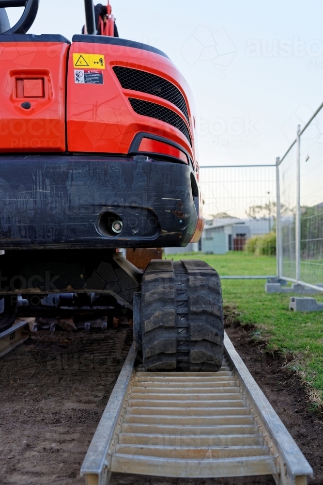 Small excavator red mini digger at a construction site - Australian Stock Image