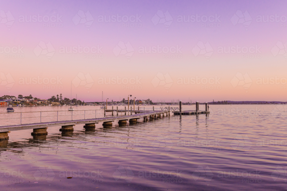 Small jetty on Lake Macquarie with purple sunset sky - Australian Stock Image
