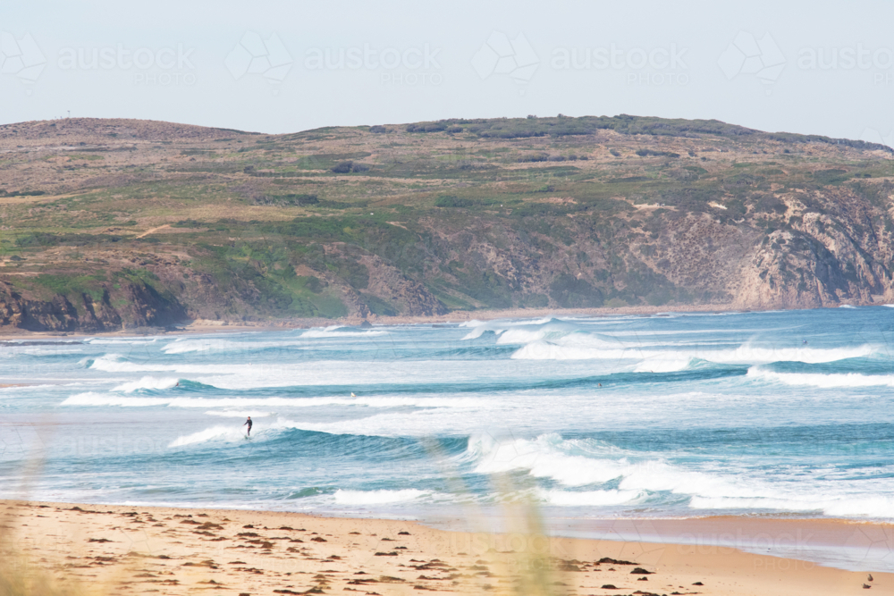 Small lone surfer in big surf - Australian Stock Image
