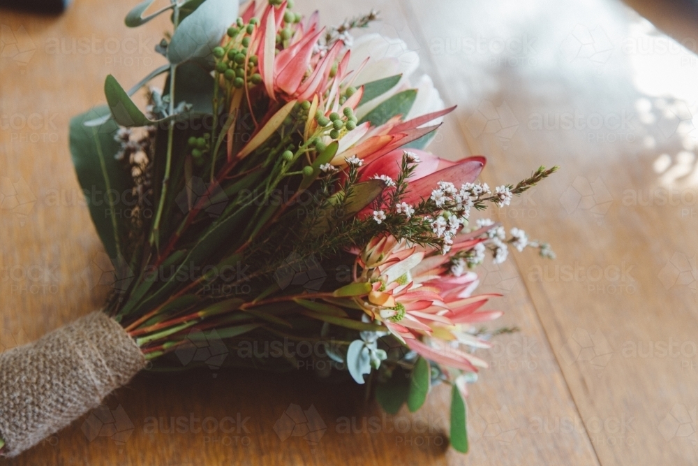 Small posy of native flowers, sitting on a wooden table - Australian Stock Image
