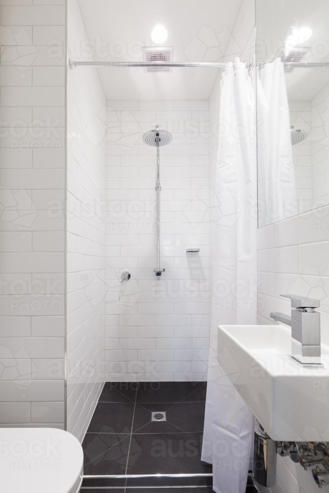 Small renovated white ensuite bathroom with rain shower - Australian Stock Image