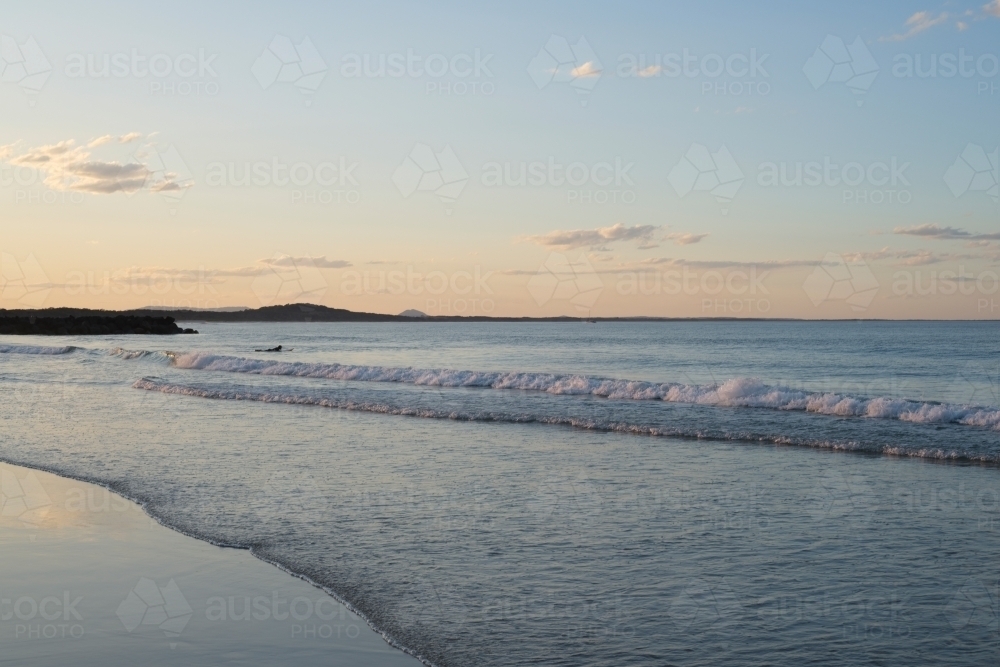 Small waves on beach at sunset - Australian Stock Image