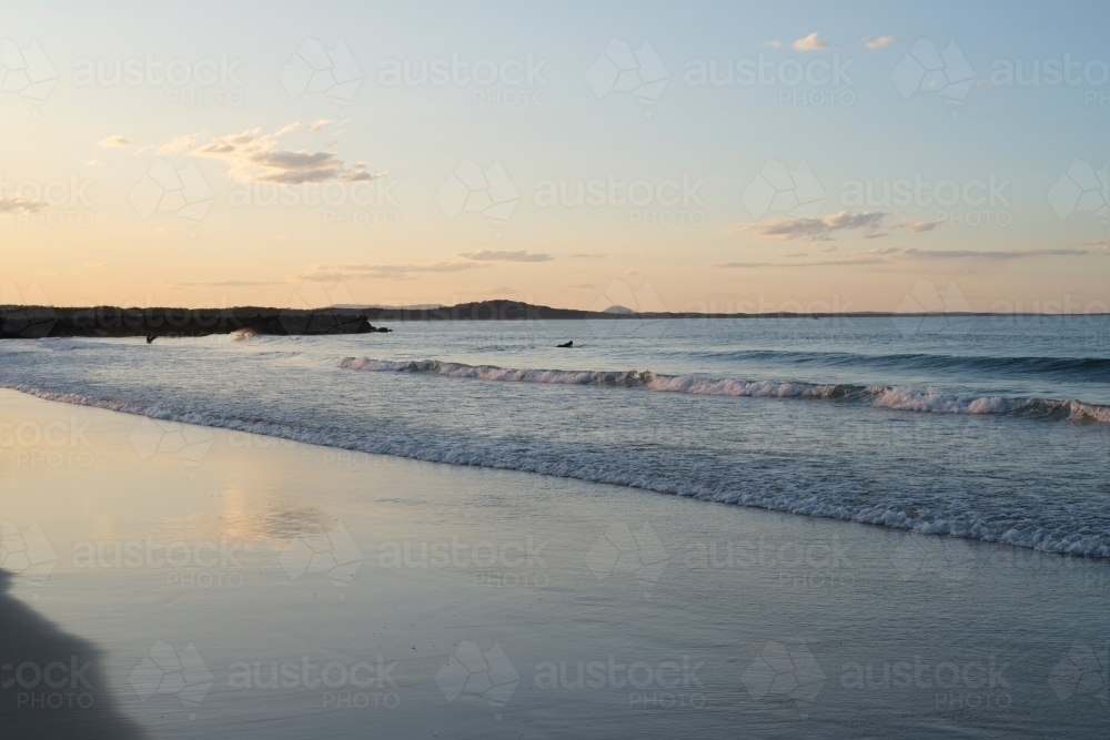 Small waves on beach at sunset - Australian Stock Image