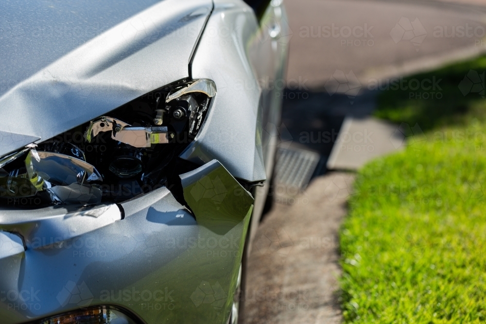 Smashed and dented side and headlight of car - Australian Stock Image