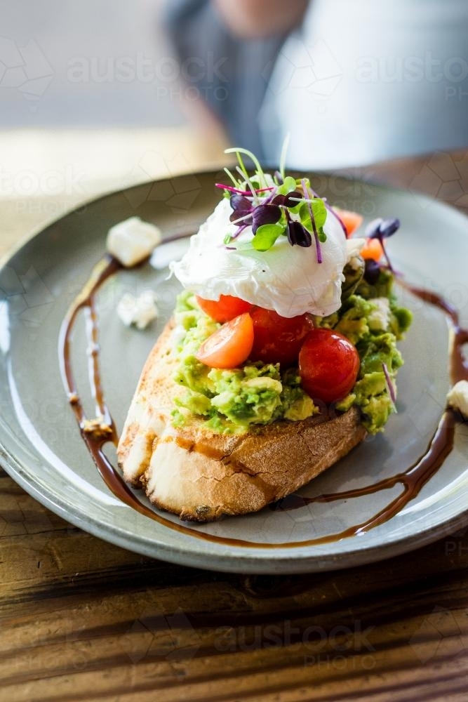 Smashed avocado on toast with a poached egg - Australian Stock Image