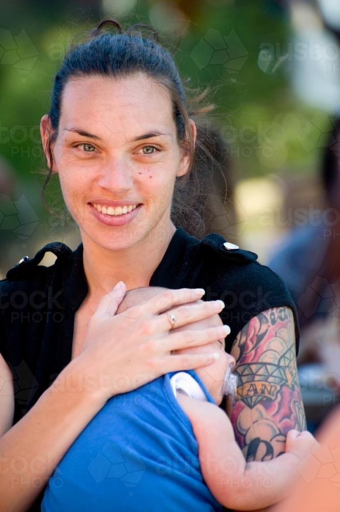 Smiling Aboriginal Mother with Baby - Australian Stock Image