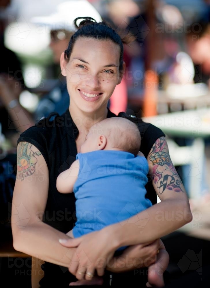 Smiling Aboriginal Woman Holding Baby - Australian Stock Image