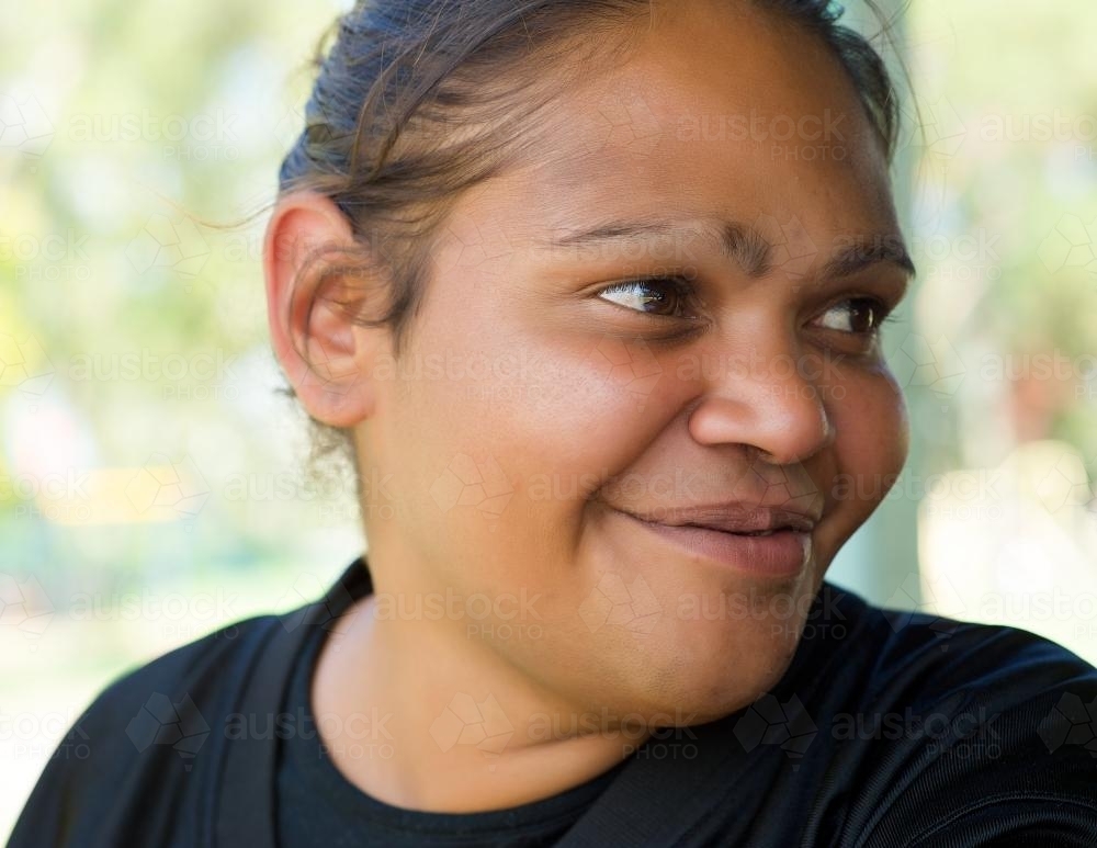 Smiling Aboriginal Woman on a Green Background - Australian Stock Image
