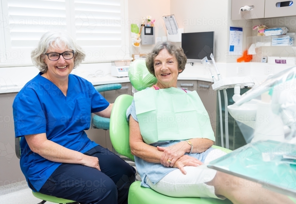 Smiling elderly female patient with dentist - Australian Stock Image