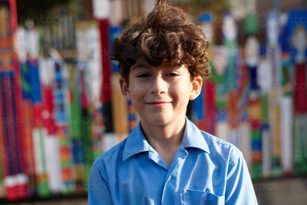 Smiling happy young school boy at school - Australian Stock Image