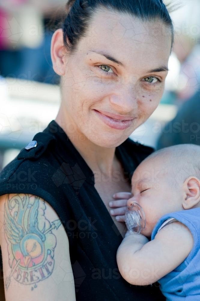 Smiling Indigenous Australian Woman with Baby in Arms - Australian Stock Image